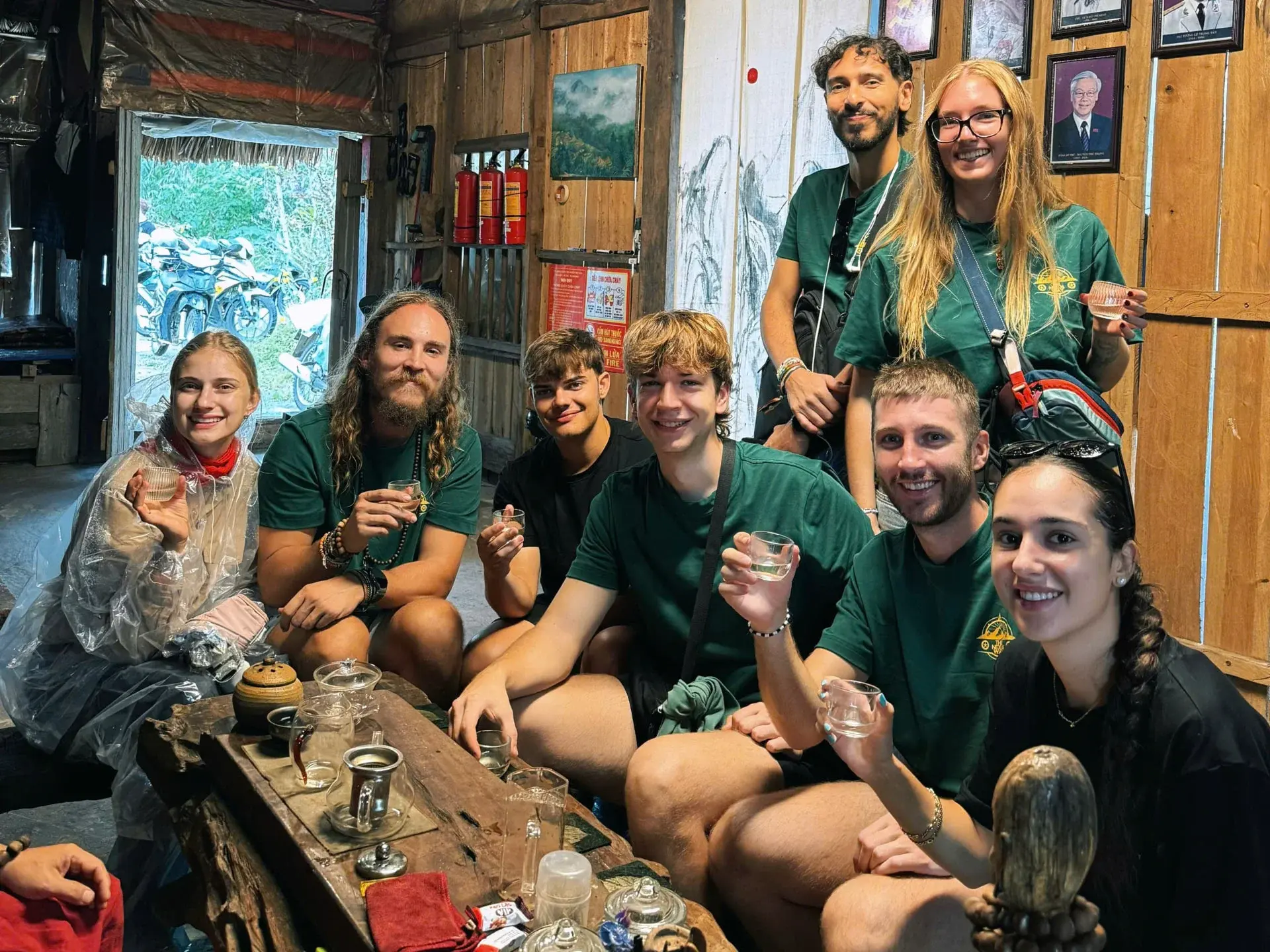 Nexus group sharing tea and happy water at a wooden homestay after a day riding the Ha Giang Loop